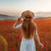 une jeune femme dans un champ de coquelicots au coucher du soleil
